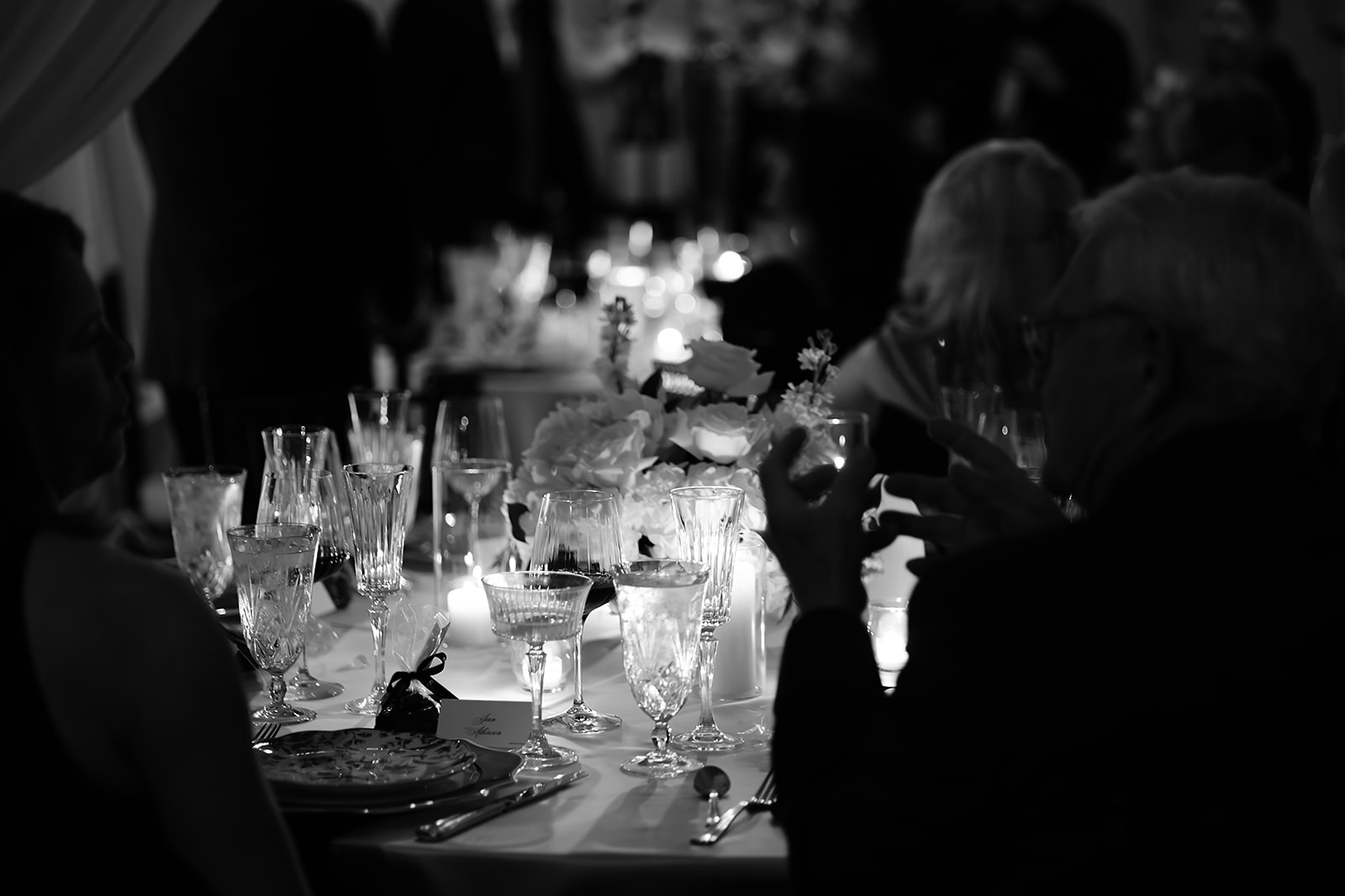 Candlelit, classy wedding reception with white florals and checkered dancefloor. 