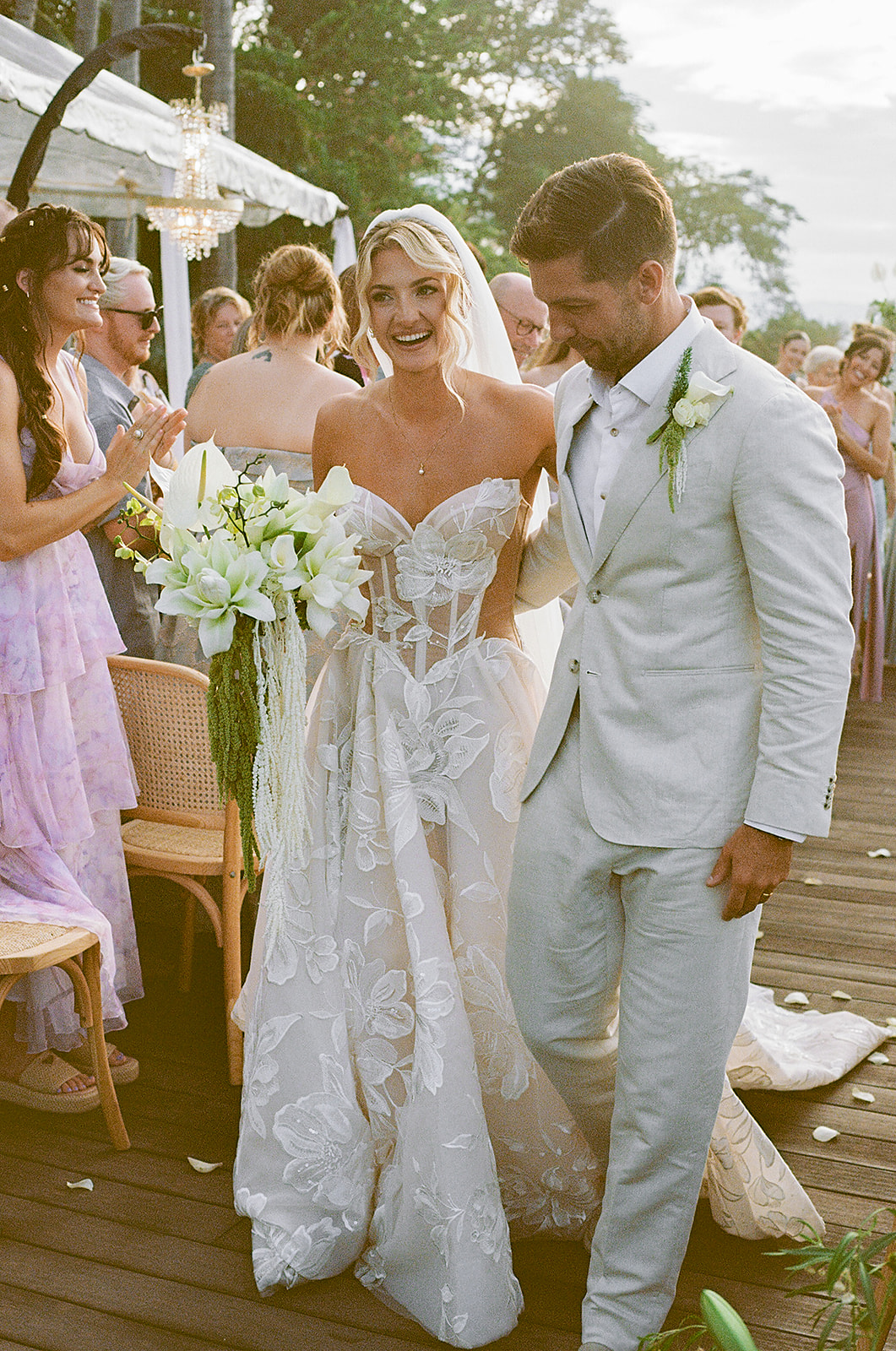 Newlyweds walking down aisle on wooden deck above the sea in Mexico taken on 35mm film