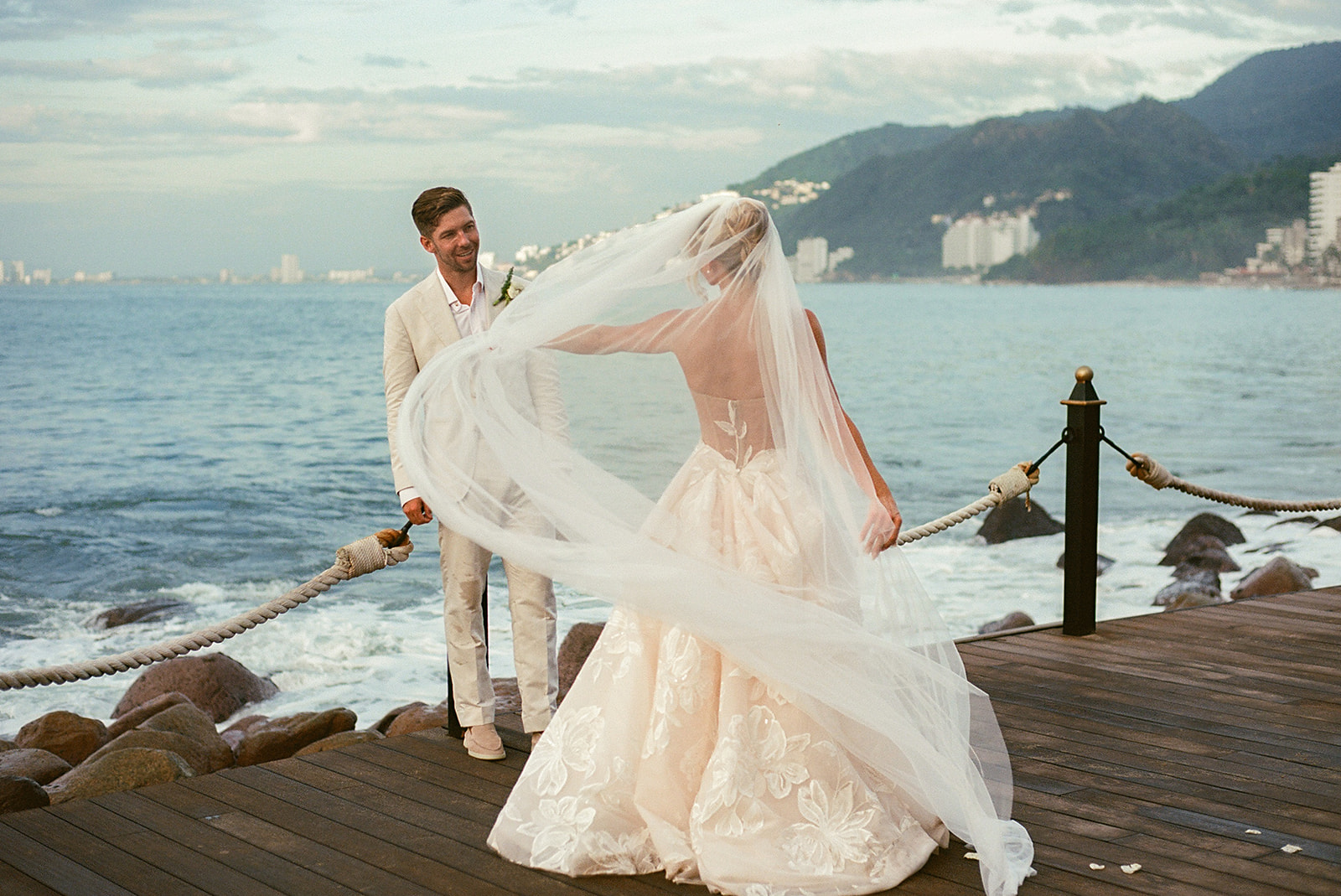 Movement-based portrait of newlyweds along rocky shoreline taken on 35mm film
