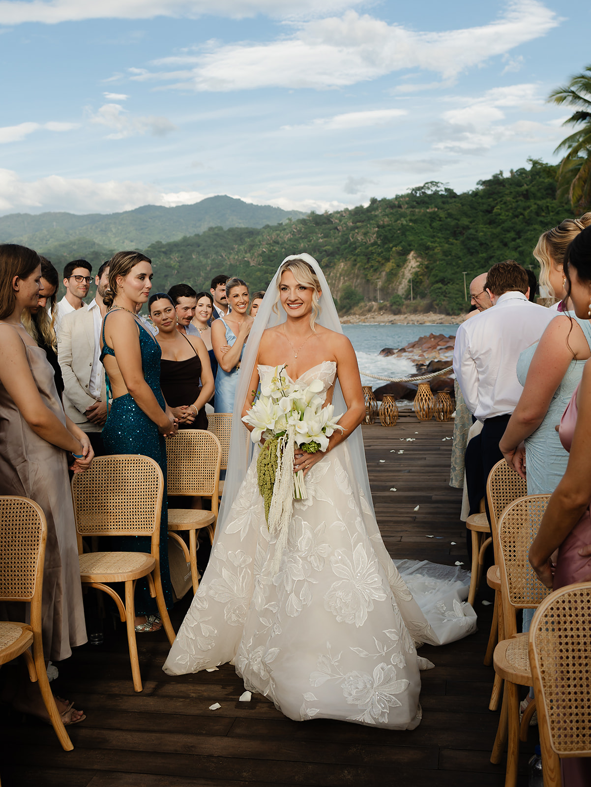Bride walking toward ceremony overlooking rocky Puerto Vallarta coastline