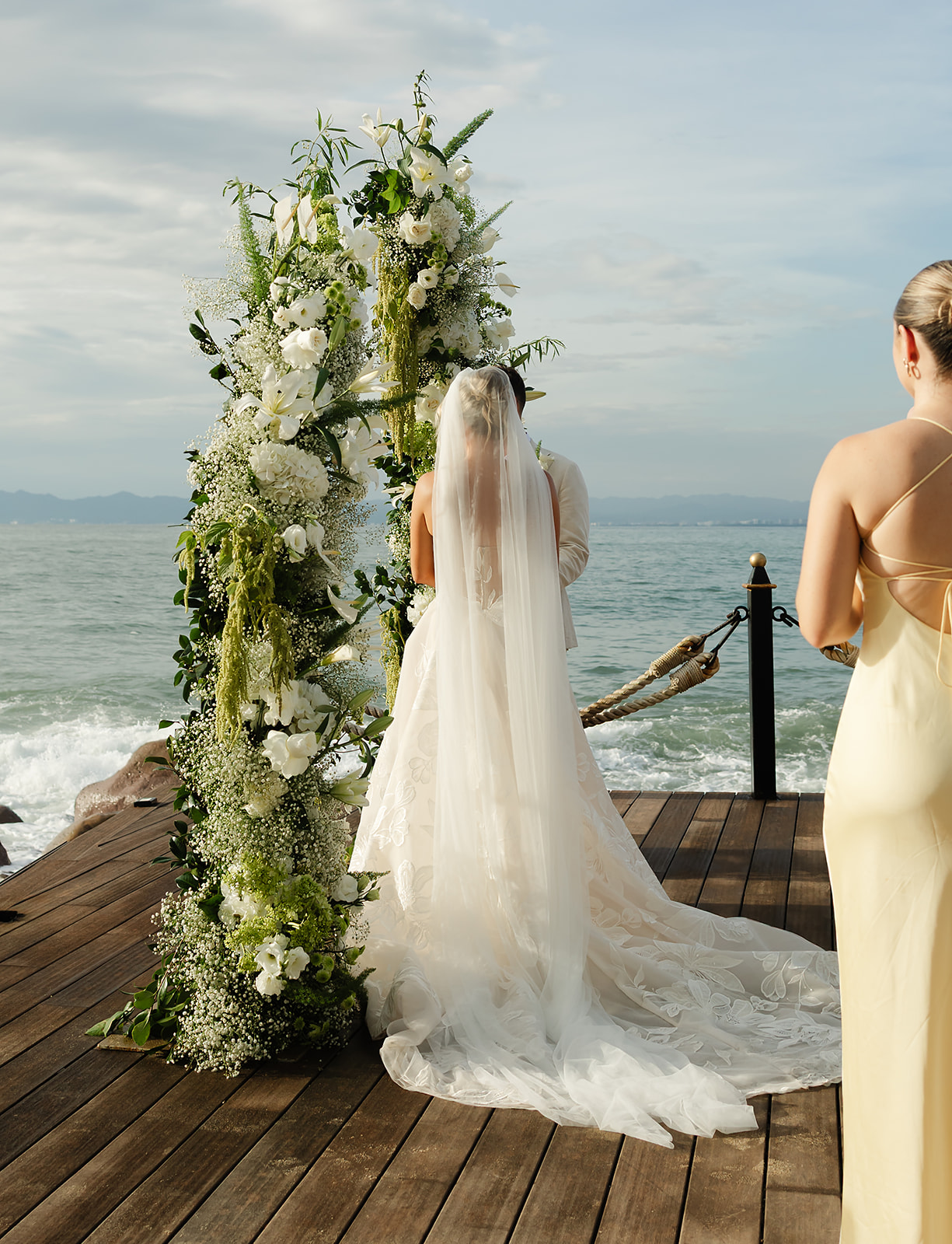 Documentary style photo of wedding ceremony on a deck above the ocean at private villa in Mexico