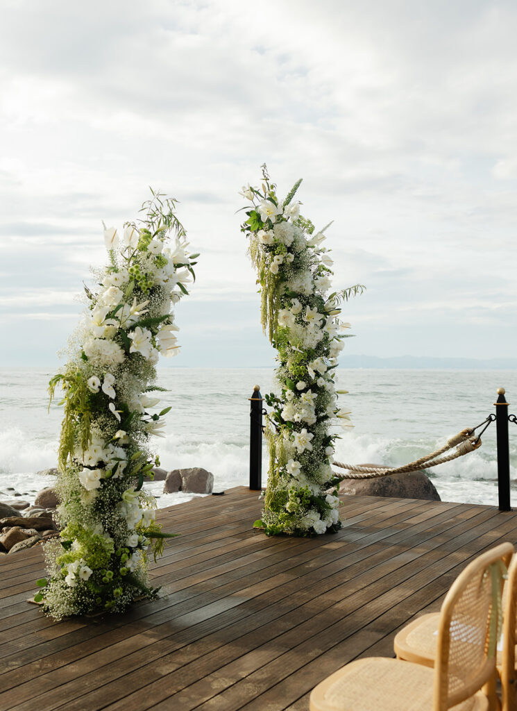 Oceanfront ceremony setup on wooden deck extending over water