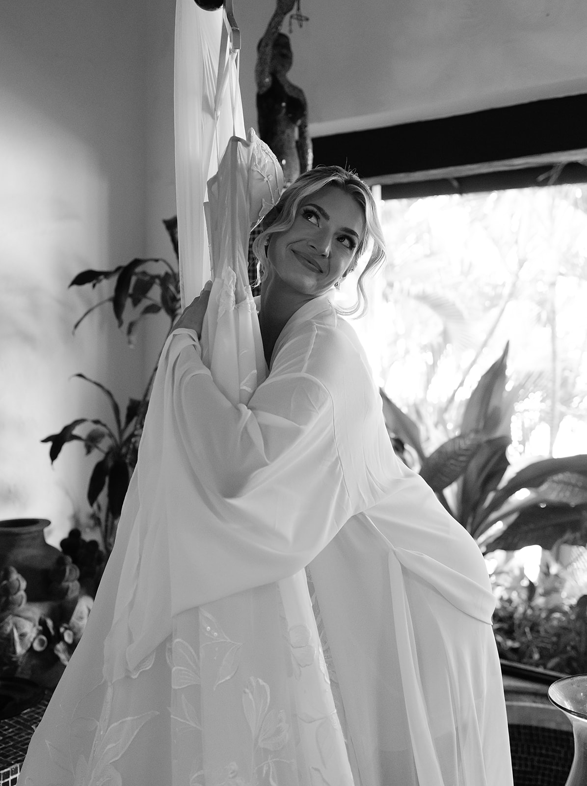 Bride hugging her wedding dress before putting it on