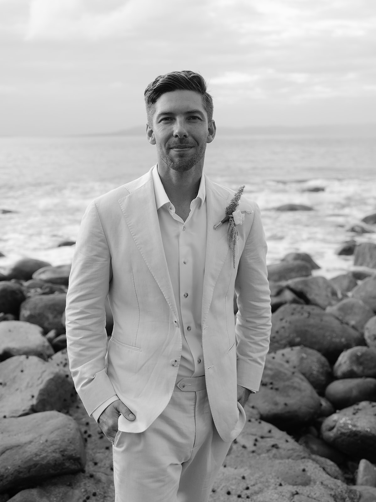 Black and white photo of groom looking at camera