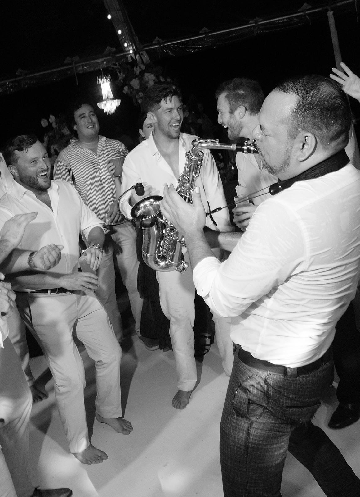 Direct flash wedding reception photo of saxophonist and guests