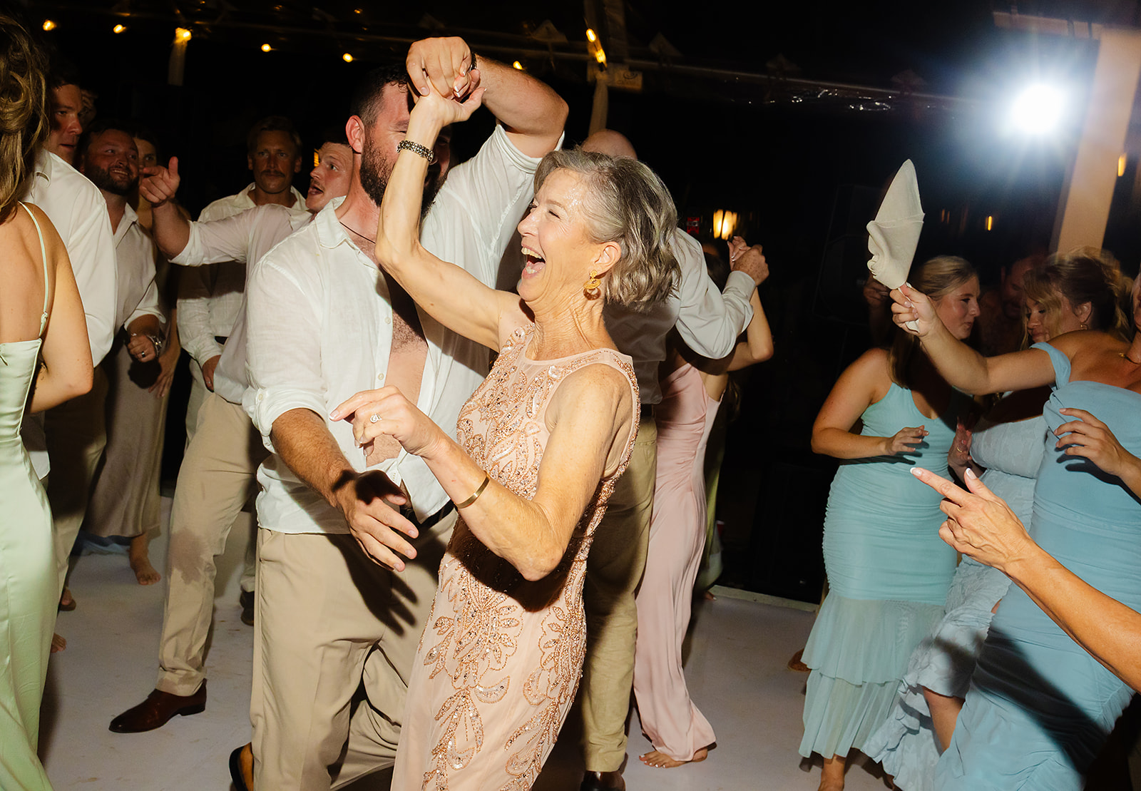 Guests dancing energetically during coastal villa reception party