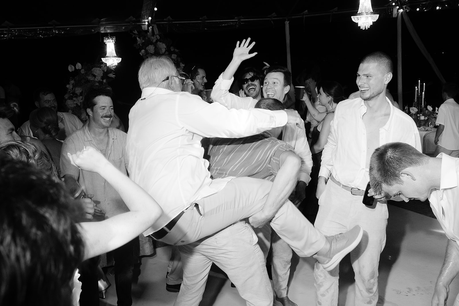 Group of guests celebrating together under strobe-style reception lights