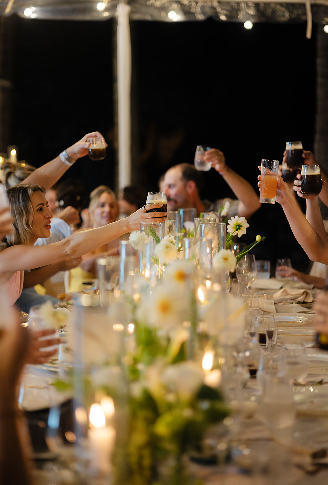 Candid wedding photo during toasts of guests cheersing 